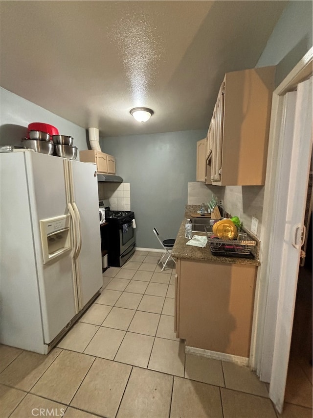 kitchen with black gas range, light brown cabinets, white fridge with ice dispenser, light tile patterned floors, and a textured ceiling