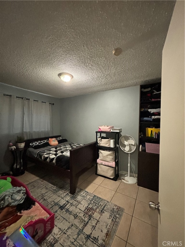 bedroom featuring a textured ceiling and light tile patterned floors