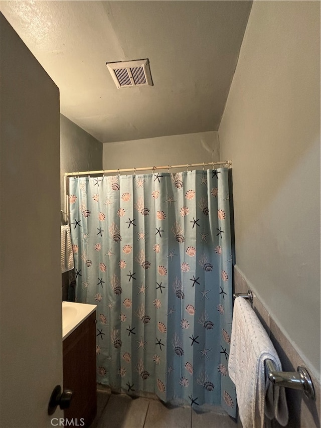 bathroom featuring vanity, tile patterned floors, and walk in shower