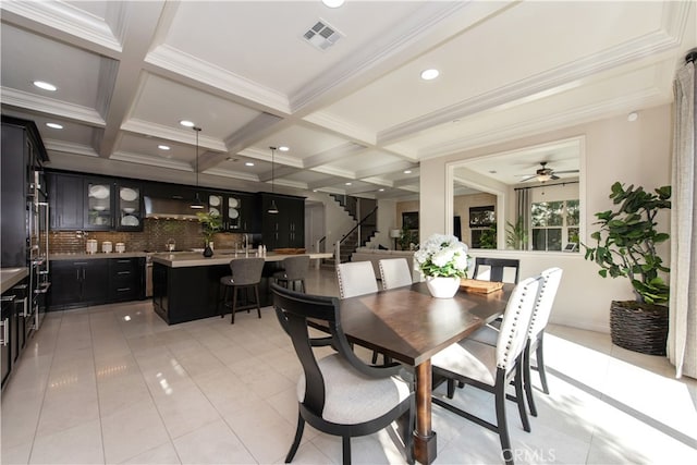 dining area with coffered ceiling, light tile patterned floors, beamed ceiling, crown molding, and ceiling fan