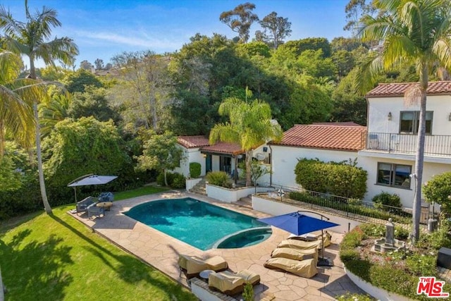 view of pool featuring a lawn and a patio area