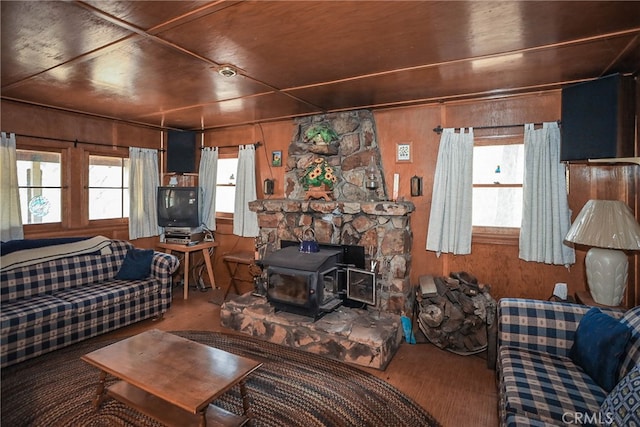 living room with wood walls, a wood stove, and wooden ceiling