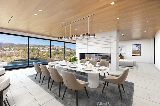 dining area featuring a fireplace, light tile patterned flooring, and wooden ceiling