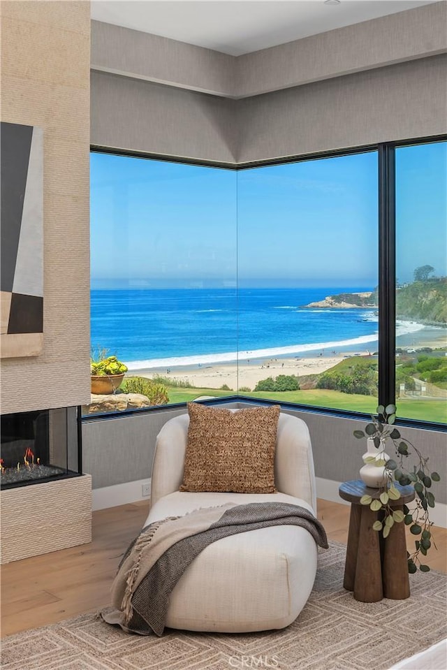 13 Ritz Cove Dr, Dana Point, CA 92629 - sitting room with wood finished floors, a water view, healthy amount of natural light, and a multi sided fireplace