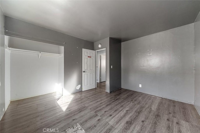 unfurnished bedroom with light hardwood / wood-style flooring and a closet