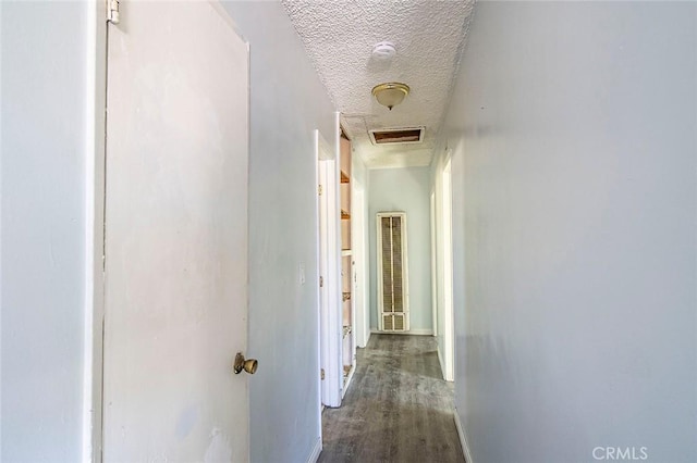 hallway featuring a textured ceiling and dark wood-type flooring