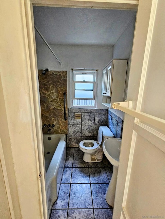 full bathroom featuring sink, tile patterned flooring, toilet, tile walls, and tub / shower combination