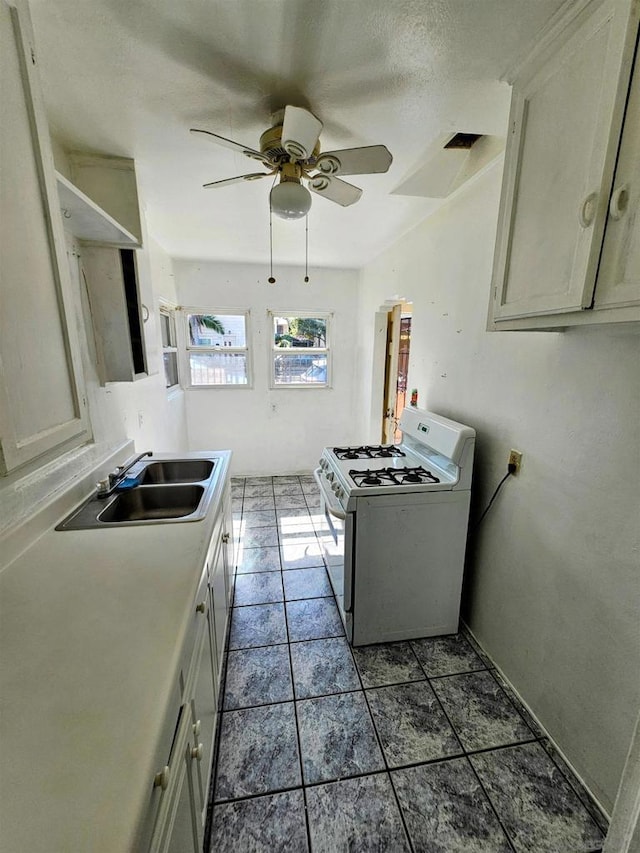 kitchen featuring white cabinetry, ceiling fan, sink, a textured ceiling, and white gas range oven