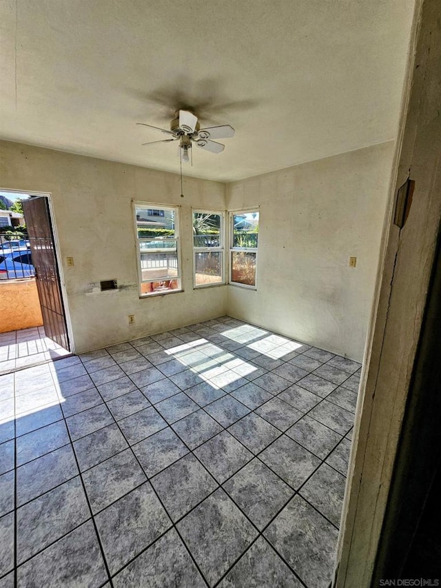 unfurnished room with ceiling fan and light tile patterned flooring