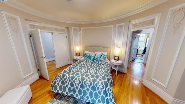 bedroom featuring wood-type flooring, a closet, and crown molding