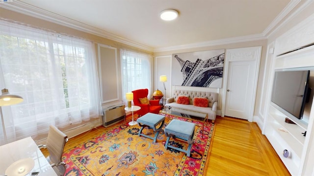 living area with hardwood / wood-style flooring and crown molding