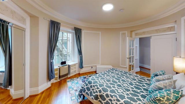 bedroom with crown molding, a closet, and wood-type flooring