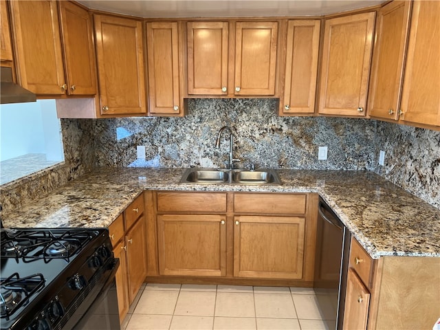 kitchen with dark stone counters, dishwasher, light tile patterned floors, and sink