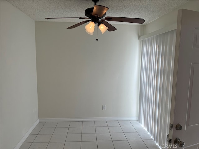 empty room featuring ceiling fan, a textured ceiling, and light tile patterned floors