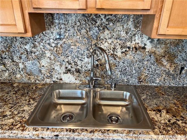 room details with dark stone countertops, tasteful backsplash, and sink