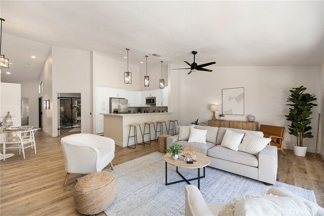 living room featuring light wood-type flooring, lofted ceiling, and ceiling fan