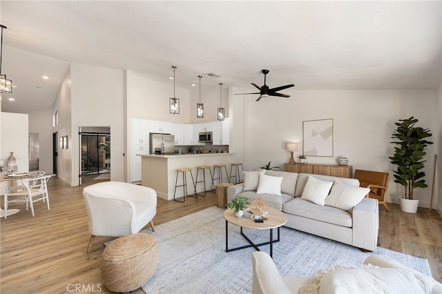 77640 Woodhaven Dr N, Palm Desert, CA 92211 - living room with light wood-style floors, high vaulted ceiling, and ceiling fan