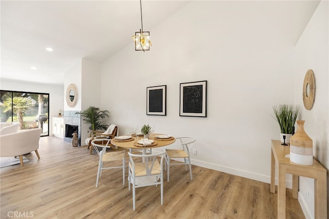 77640 Woodhaven Dr N, Palm Desert, CA 92211 - dining area featuring light wood-type flooring, high vaulted ceiling, recessed lighting, and a fireplace