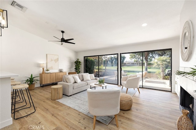 living room featuring light wood-type flooring, vaulted ceiling, and ceiling fan