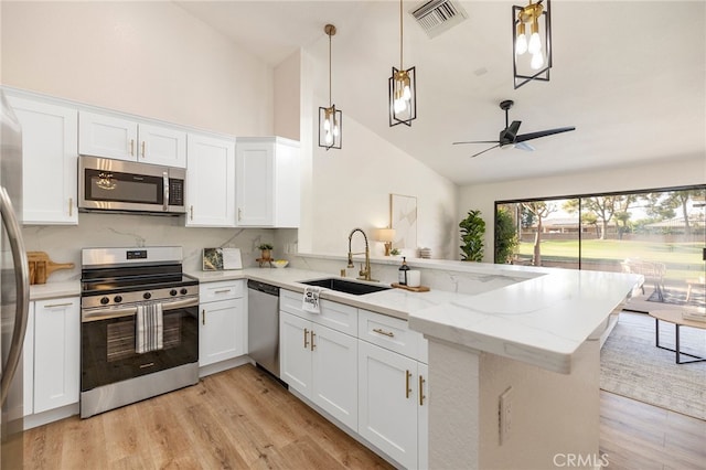 77640 Woodhaven Dr N, Palm Desert, CA 92211 - kitchen featuring stainless steel appliances, a peninsula, high vaulted ceiling, white cabinetry, and light wood-type flooring