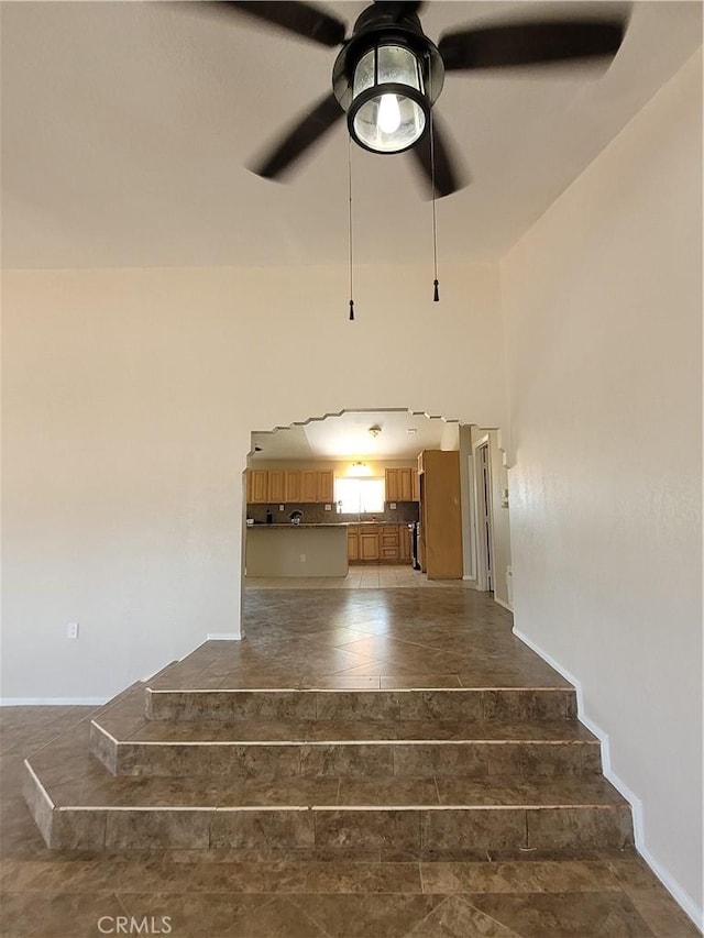 stairs featuring ceiling fan