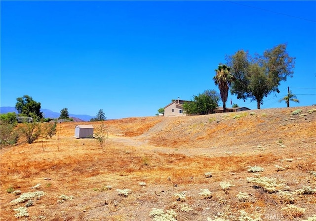 view of yard with a mountain view and a rural view