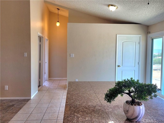 interior space with a textured ceiling and vaulted ceiling