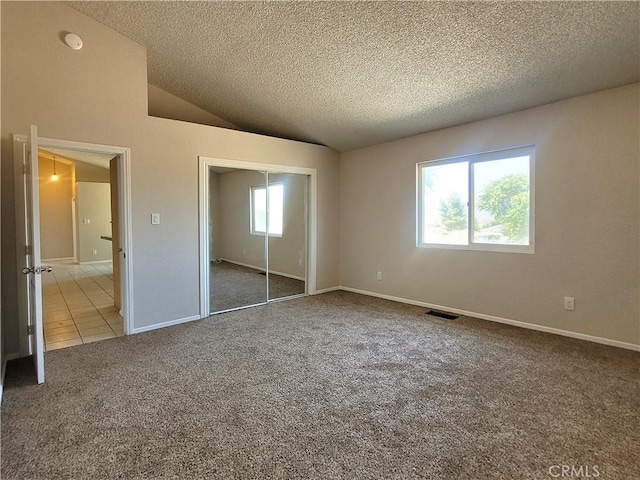 unfurnished bedroom featuring carpet floors, a textured ceiling, and multiple windows