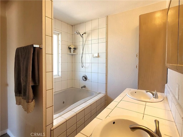 bathroom featuring vanity and tiled shower / bath combo