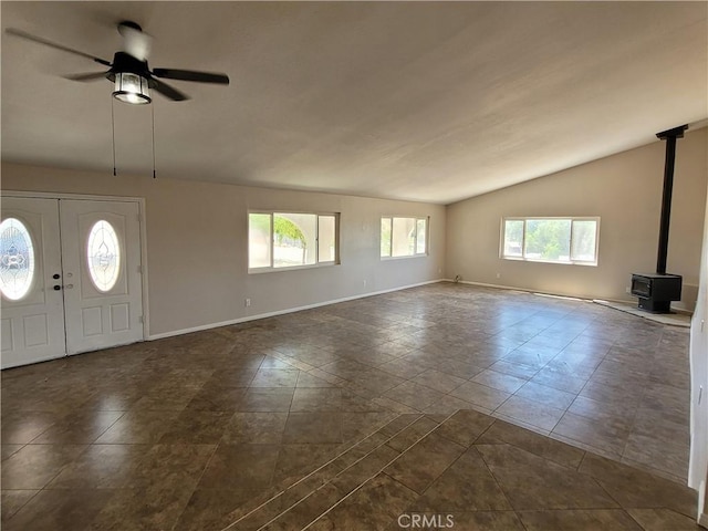 foyer featuring ceiling fan, a healthy amount of sunlight, and a wood stove