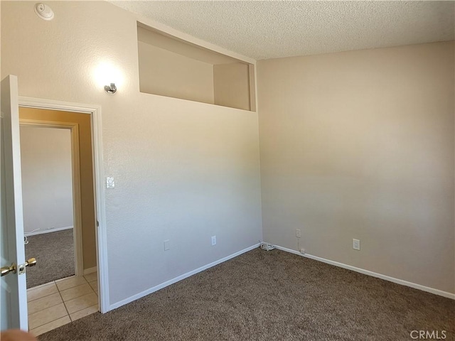 empty room featuring carpet and a textured ceiling