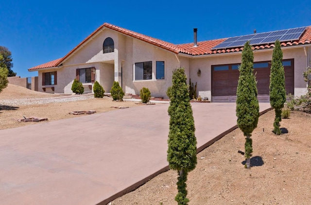 view of front of property featuring solar panels and a garage