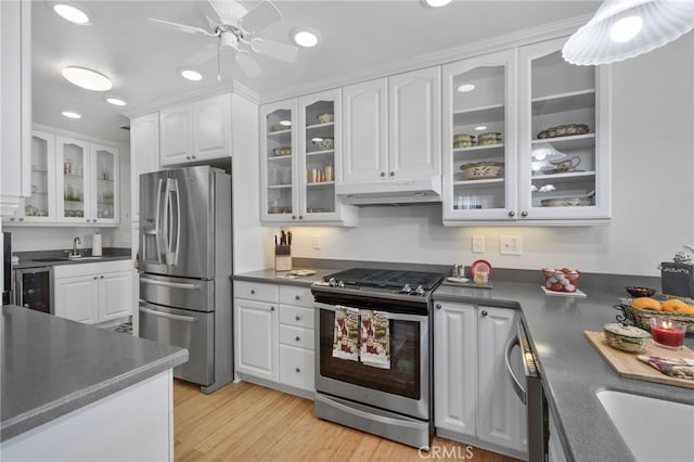 kitchen with ceiling fan, sink, white cabinetry, appliances with stainless steel finishes, and light hardwood / wood-style floors