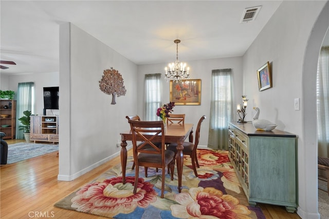 dining room featuring ceiling fan with notable chandelier and hardwood / wood-style floors