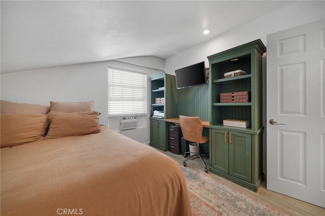 bedroom with a textured ceiling, cooling unit, lofted ceiling, and light hardwood / wood-style flooring