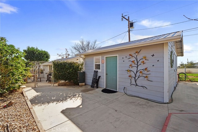 rear view of house featuring an outdoor structure and a patio