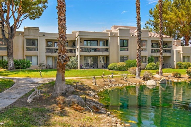 view of home's community with a water view and a lawn