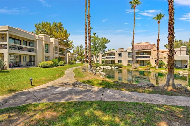 surrounding community with a lawn and a water view