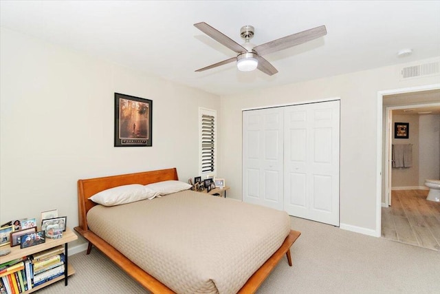 bedroom with carpet flooring, ceiling fan, ensuite bath, and a closet