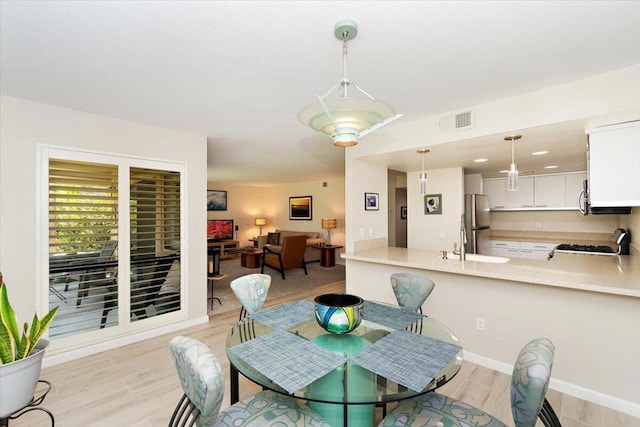 dining area with light hardwood / wood-style flooring and sink