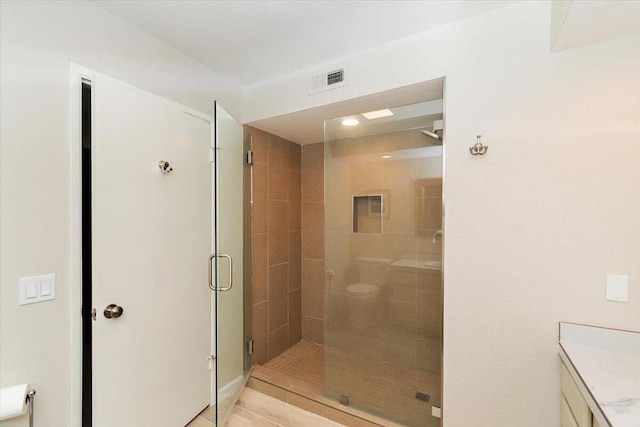 bathroom with vanity, toilet, and an enclosed shower