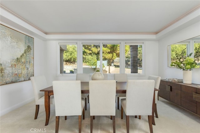 dining area with a healthy amount of sunlight, crown molding, and light colored carpet