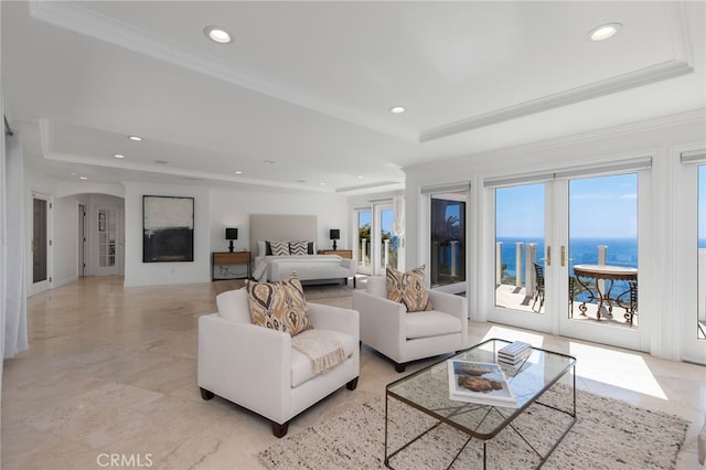 bedroom with a water view, a tray ceiling, french doors, and access to exterior