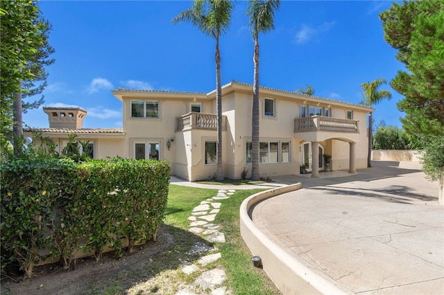 back of property featuring a lawn and a balcony