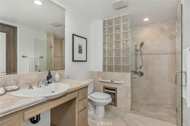 bathroom featuring tasteful backsplash, a shower with door, ornamental molding, vanity, and toilet