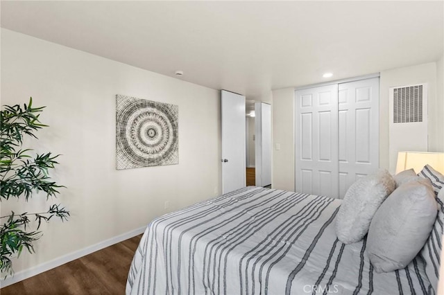 bedroom with dark hardwood / wood-style floors and a closet