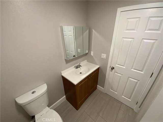 bathroom with tile patterned floors, toilet, vanity, and baseboards