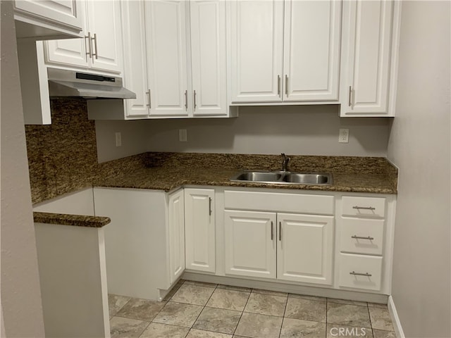 kitchen featuring sink, light tile patterned floors, and white cabinets