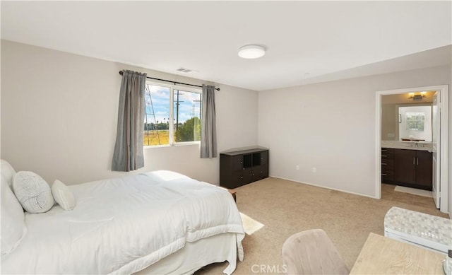 bedroom featuring light colored carpet, connected bathroom, and sink