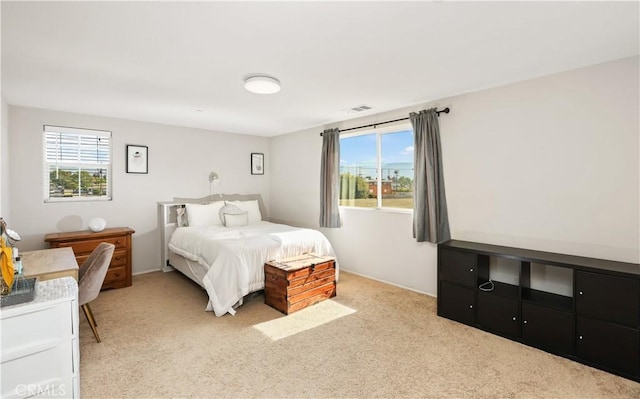 bedroom with light carpet and multiple windows